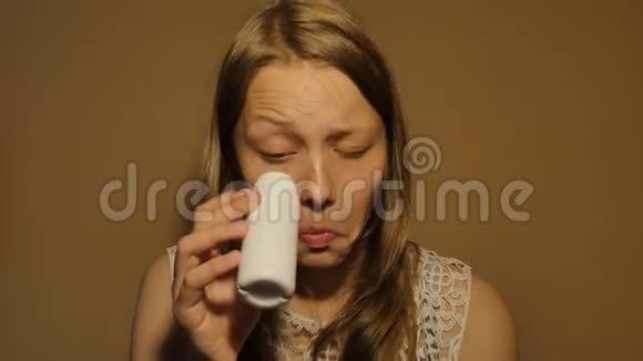 十几岁的女孩从一个小瓶子里喝牛奶或酸奶4UHDK视频的预览图