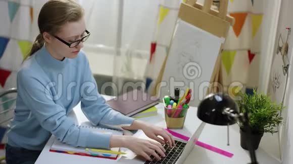 年轻漂亮的女学生用笔记本做作业视频的预览图