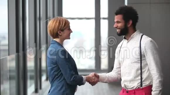 女性创意总监和男性广告主管握手简介视频的预览图