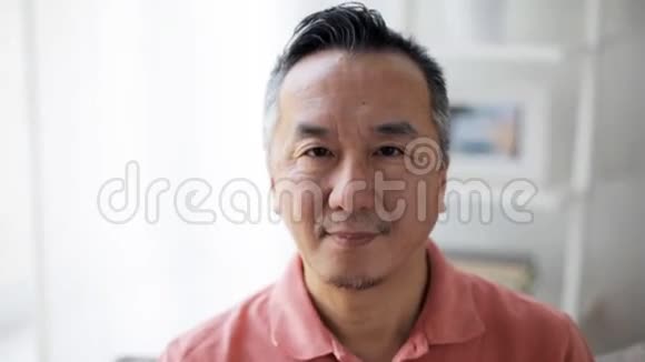 一个微笑的亚洲男人在家的脸视频的预览图