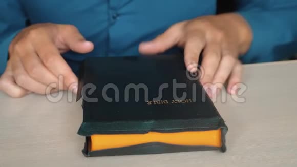布道者用双手放在圣经慢动作视频上祈祷上帝这个人正在读一本圣经书视频的预览图