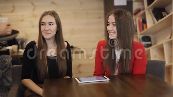 年轻的女人在咖啡馆里从服务员那里得到咖啡视频的预览图