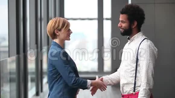 女性创意总监和男性广告主管握手简介视频的预览图