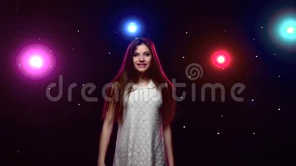 长发女孩在迪斯科灯光下旋转慢动作视频的预览图