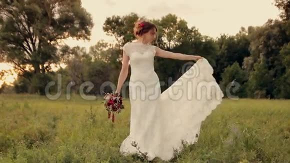 年轻美丽的新娘站在田野里视频的预览图