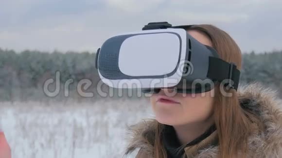女人在冬天的森林里用虚拟现实眼镜视频的预览图