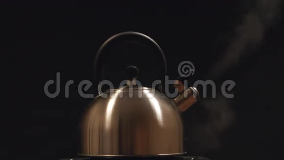 从黑色背景的钢水壶中蒸出来的蒸汽视频的预览图