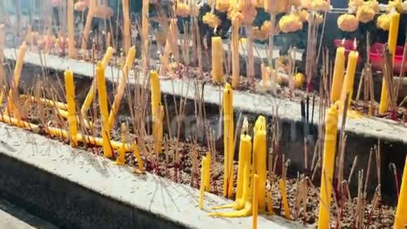 曼谷寺庙里的蜡烛烟和黄花视频的预览图