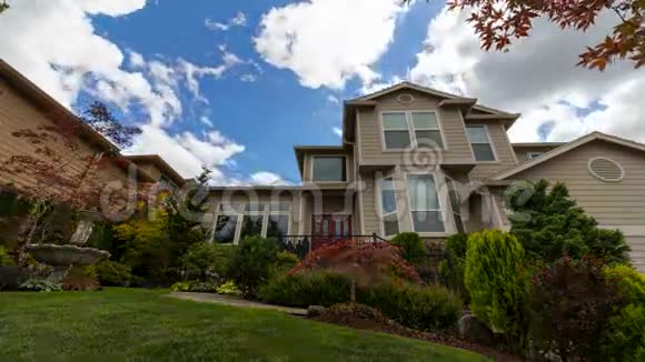 UHD电影移动的云和蓝天覆盖郊区的家修剪草坪和花园视频的预览图