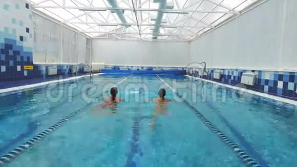 两个年轻女人在游泳池里聊天和游泳视频的预览图