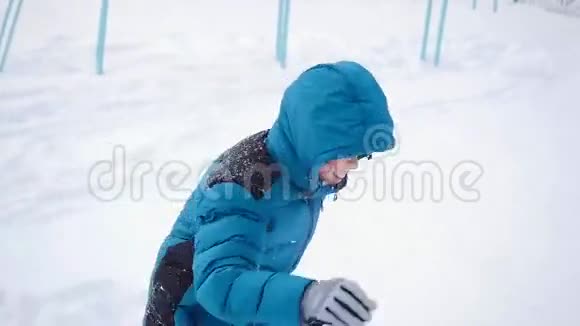 冬天一个快乐的小孩子在操场上玩耍在雪地里翻腾视频的预览图