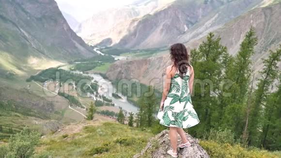山里的年轻女子穿着一件漂亮的衣服跑步走路旋转享受大自然视频的预览图