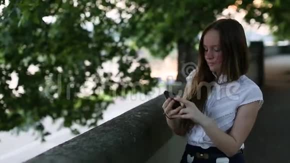 十几岁的女孩在智能手机上自拍给自己拍照视频的预览图