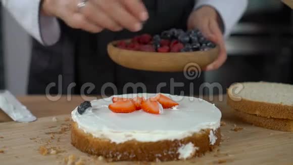 女人做蛋糕用浆果装饰饼干视频的预览图