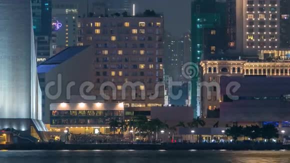 人们坐在靠近香港文化中心的楼梯上手掌和塔在背景时间推移视频的预览图
