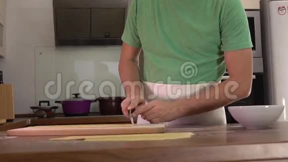 穿绿色衣服的人用刀子切自制的意大利面业余在家做饭4Ksteatam视频视频的预览图
