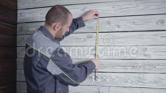工人用尺子量一堵木墙视频的预览图