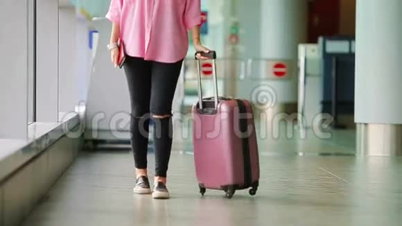 机场休息室配有护照登机牌和粉红色行李的近距离飞机乘客年轻女子视频的预览图