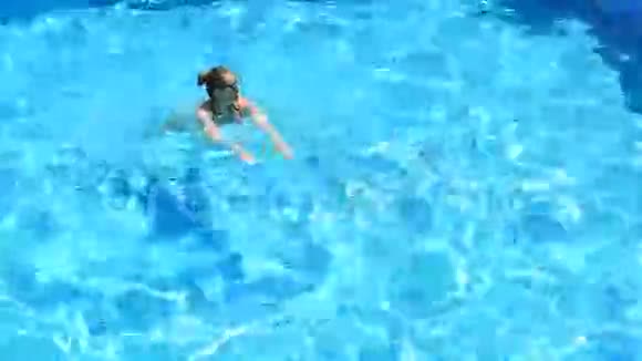 金发美女在游泳池里享受着水从上面看视频的预览图