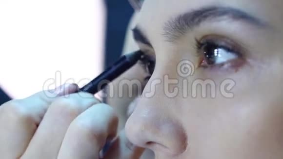 化妆师将化妆应用于一个有吸引力的年轻女性视频的预览图