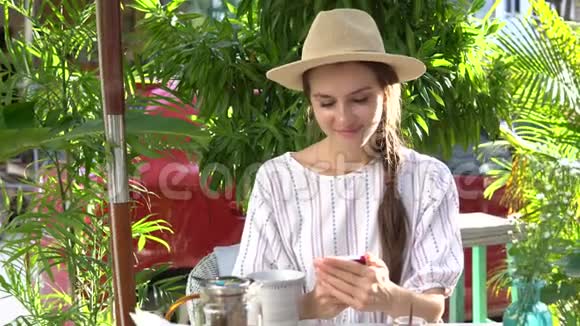 女人一边喝茶一边用手机视频的预览图