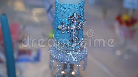装饰蓝色蜡烛白色大装饰蜡烛与神圣十字架蜡烛上十字架的身影选择性视频的预览图