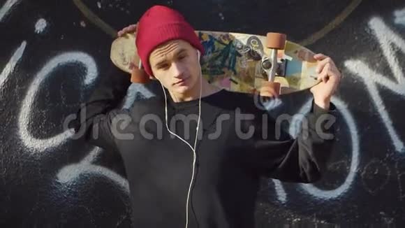 在涂鸦墙前玩滑板的青少年视频的预览图