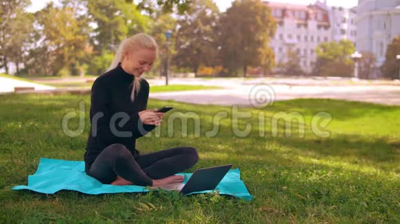 金发女郎在户外使用笔记本电脑视频的预览图