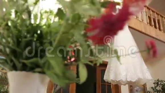 一件完美的婚纱在新娘房间的衣架上有一条完整的裙子上面有蓝色的窗帘视频的预览图