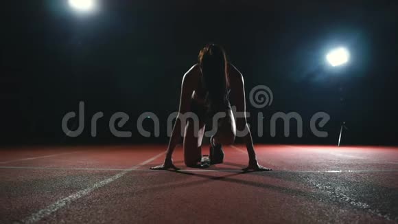 瘦小的女运动员可以在跑道上的垫子上缓慢地运动视频的预览图