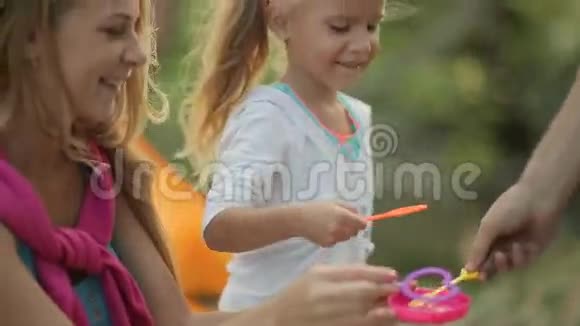 小女孩和家人一起吹肥皂泡视频的预览图