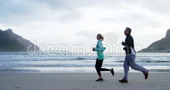 成熟的情侣在海滩上慢跑视频的预览图