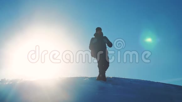 男子旅行者在冬季登山剪影阳光慢动作视频旅行生活方式冒险冬天视频的预览图