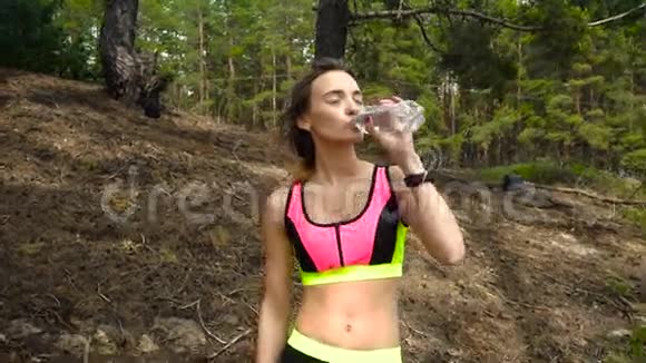 年轻漂亮的运动女孩喝水视频的预览图