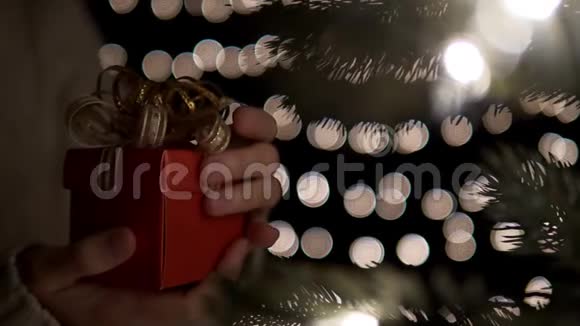 女子打开红色圣诞礼品盒背景灯视频的预览图