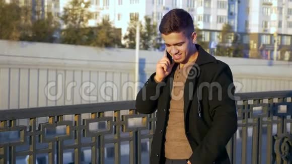日落时分穿着得体的时髦男人在城市里用手机聊天视频的预览图