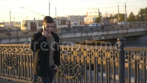 日落时分穿着得体的时髦男人在城市里用手机聊天视频的预览图