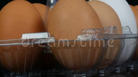 白色透明塑料托盘中的大棕色和一个白色鸡蛋视频的预览图