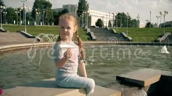 美丽的女孩在喷泉里发射纸船视频的预览图