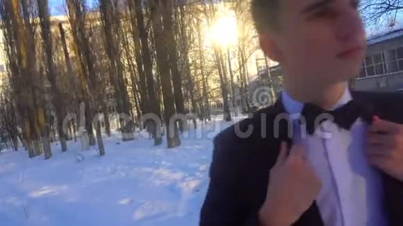 穿着燕尾服的年轻人在冬天迎着白雪穿着复古风格视频的预览图