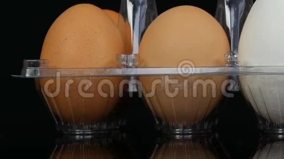 白色透明塑料托盘中的大棕色和一个白色鸡蛋视频的预览图