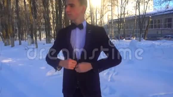 穿着燕尾服的年轻人在冬天迎着白雪穿着复古风格视频的预览图