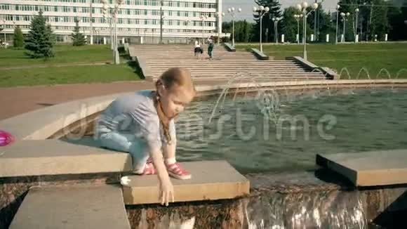 美丽的女孩在喷泉里发射纸船视频的预览图