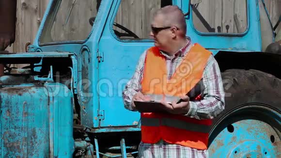 工人在拖拉机附近写字视频的预览图