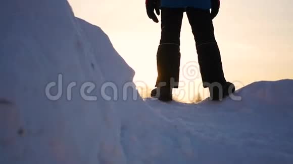 这家伙在一个雪坡上在日落时举起双手下雪的冬天风景户外运动视频的预览图