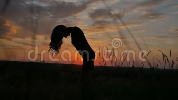 夕阳下站着的女孩飘动的头发慢动作视频视频的预览图