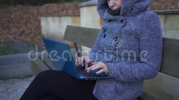 在公园长椅上写笔记本的女人视频的预览图