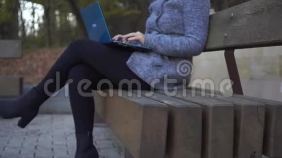 在公园长椅上写笔记本的女人视频的预览图