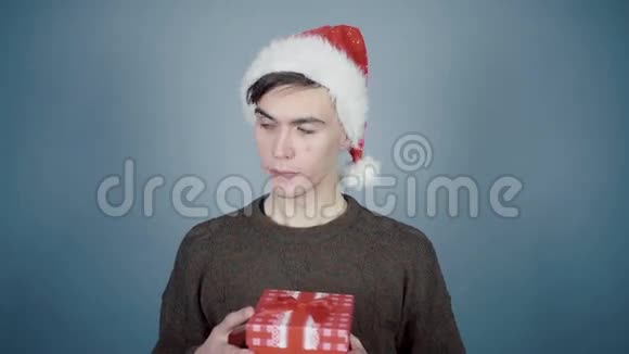 戴着圣诞帽的年轻人打开礼物盒拿出一块饼干视频的预览图
