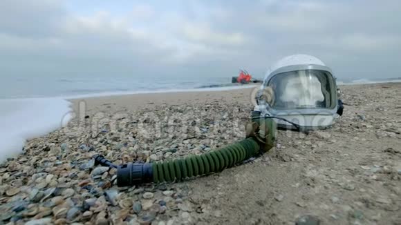 地球上死去的宇航员头盔中头部的头骨躺在海边的沙子上因为意外而困扰视频的预览图